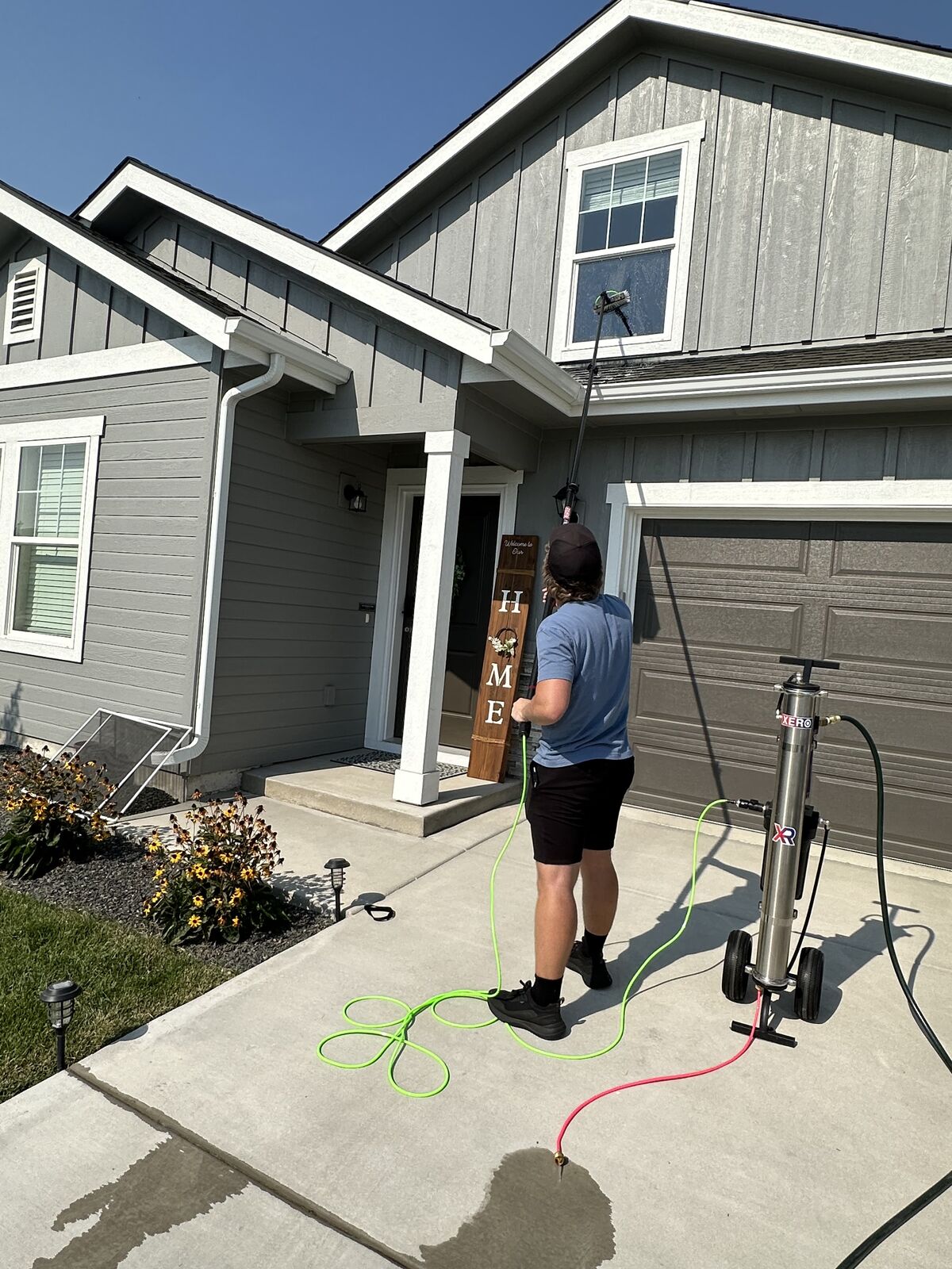 Asche Brothers cleaning second-story windows with a water-fed pole